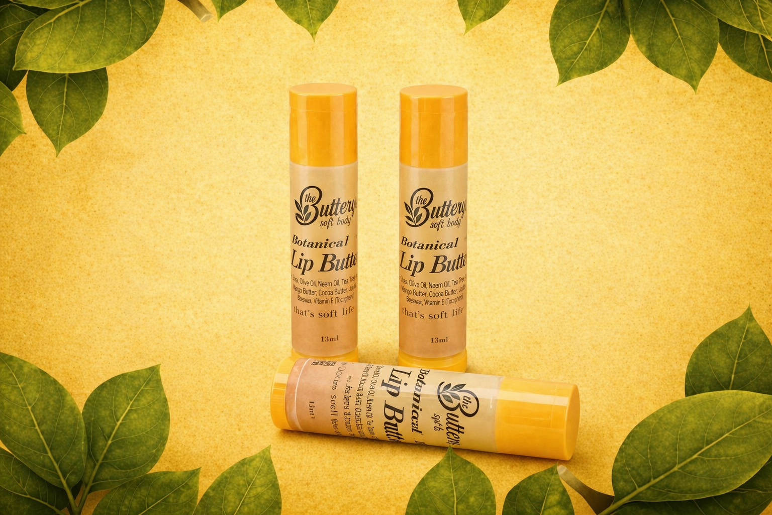 Butter lip balm tubes on a yellow background with green leaves